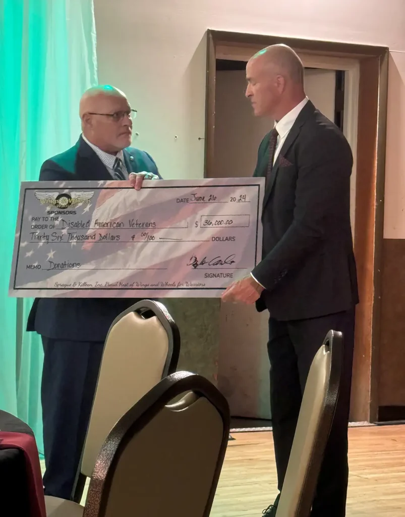 Dwight Coombe presenting large check from collected donations.
