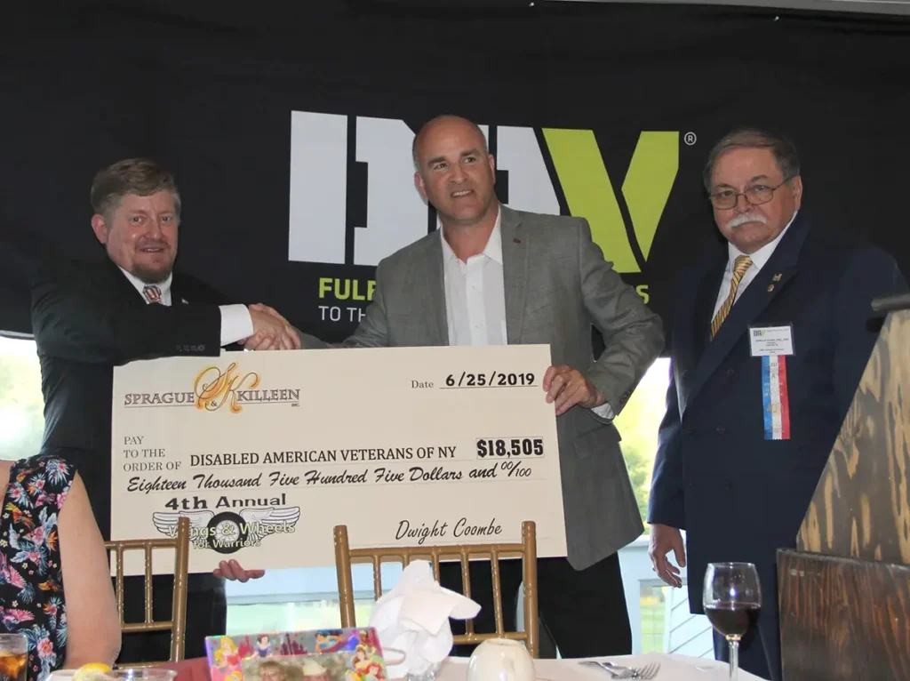 Dwight Coombe presenting large check from collected donations.